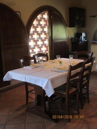 a dining room table with a white table cloth on it at La Colombarola Agriturismo in Farneto
