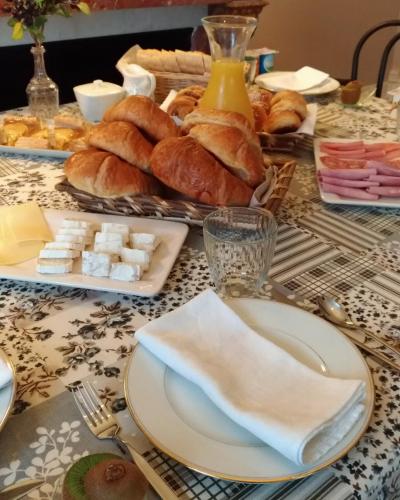 un tavolo con un piatto di pane e dolci sopra di L'Entrée Chambres d'Hôtes Bar & Restaurant a Castillonnès