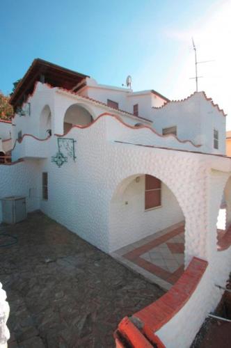 a white building with a red stripe on it at La Rosa dei Venti in La Caletta