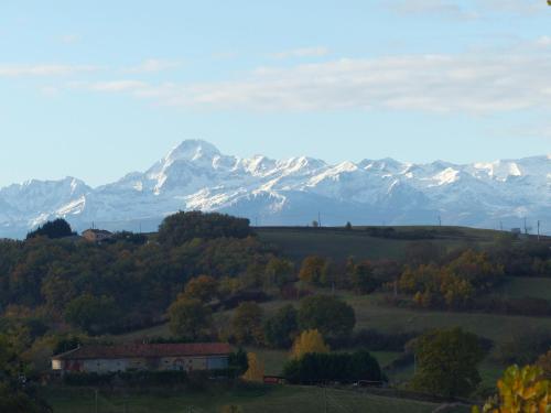 a house in a field with mountains in the background at Gites Souleilla de la Nine in Canens