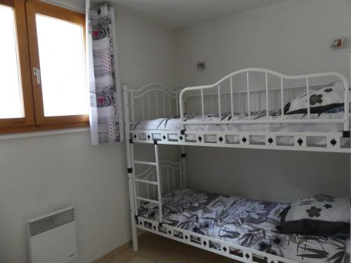 ル・ブール・ドアザンにあるLes Lys Orangésのベッドルーム1室(二段ベッド2台、窓付)が備わります。