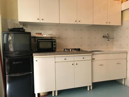 a kitchen with a black refrigerator and a microwave at Flat Low cost in Sperlonga