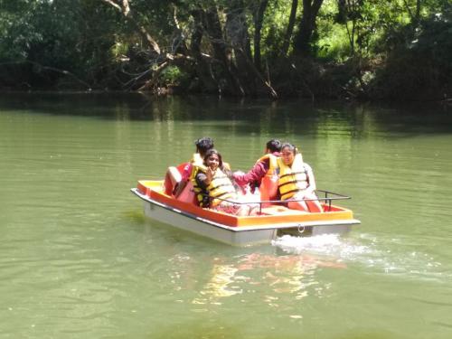 a group of people in a boat on a river at River Near Coorg in Jambur