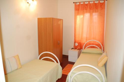Habitación pequeña con 2 camas y armario en Casa Maria, en Puntalazzo