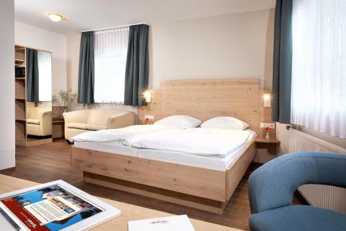 a bedroom with a bed and a table with a tablet at Hotel Heuboden in Umkirch