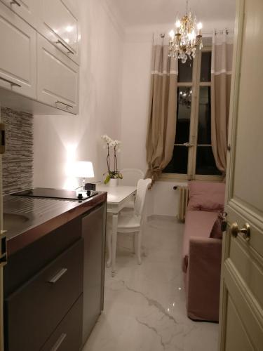 une cuisine avec une table et une salle à manger avec un lustre dans l'établissement Parc CONTINENTAL, à Cannes