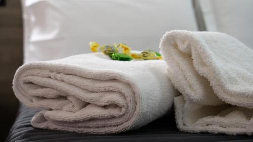 stos ręczników leżący na łóżku w obiekcie Tiburtina Royal Suites w Rzymie