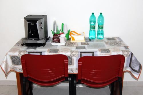 a table with two red chairs and a table with a tableablish at Casa Vacanze del Pollino in Fardella