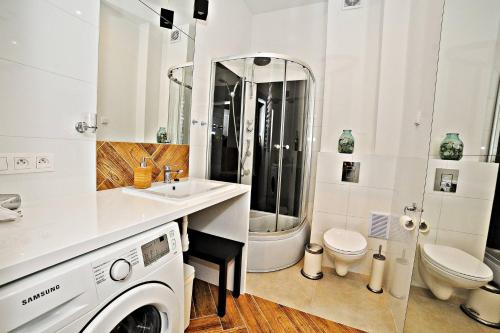 ソポトにあるSand Apartment by Grand Apartmentsのバスルーム(洗濯機、トイレ付)