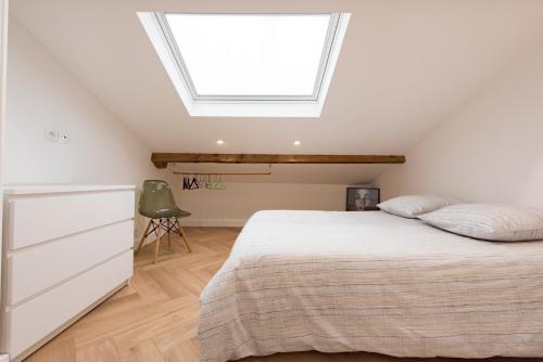 ein Schlafzimmer mit einem Bett und einem Dachfenster in der Unterkunft F2 très cosy (calme) coeur de ville 1min de la plage in Saint-Raphaël