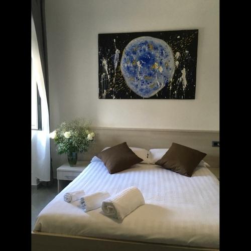 a bed in a bedroom with a painting on the wall at Il vecchio Fauno in Pompei