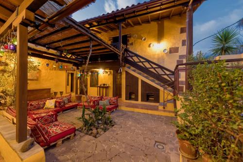an outdoor patio with red couches and a staircase at Bohemian Hideaway Finca - 2 unique houses with shared pool in Santa Lucía