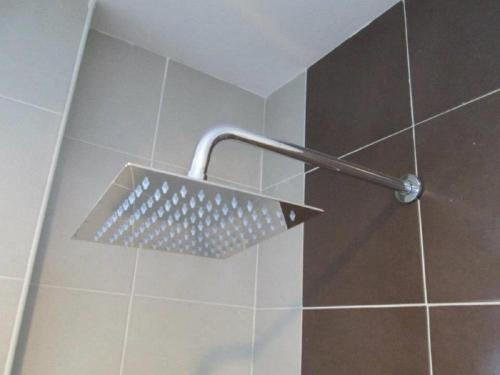 a shower with a shower head in a bathroom at Oscar Suites Hotel in Sitiawan