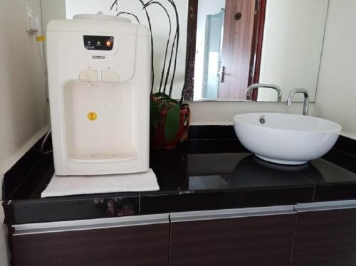 um balcão de cozinha com uma batedeira e um lavatório em Oscar Suites Hotel em Sitiawan