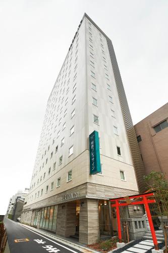 a tall white building with a sign on it at Sotetsu Fresa Inn Tokyo Kinshicho in Tokyo