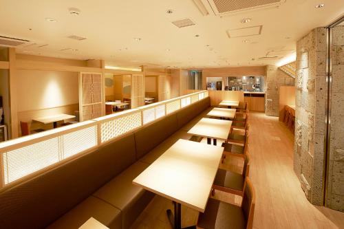a row of tables and benches in a restaurant at Sotetsu Fresa Inn Tokyo Kinshicho in Tokyo