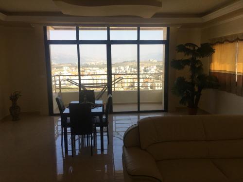 a living room with a couch and a table with chairs at Koura Nahla Apartment in An Nakhlah