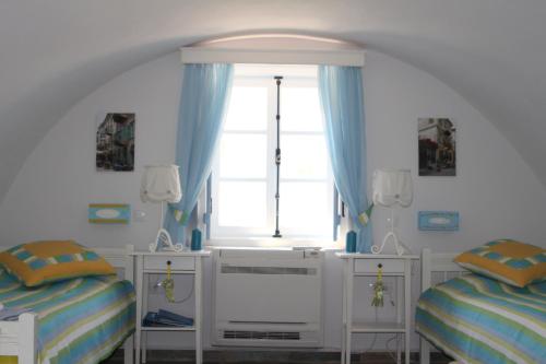 1 dormitorio con 2 camas individuales y ventana en The Studio, Leonidio, en Leonidio