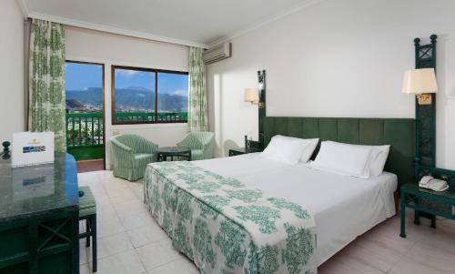 a hotel room with a bed and a balcony at Sol Puerto de la Cruz Tenerife in Puerto de la Cruz