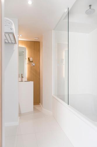 a bathroom with a glass shower and a sink at Seeko'o Hotel Bordeaux in Bordeaux