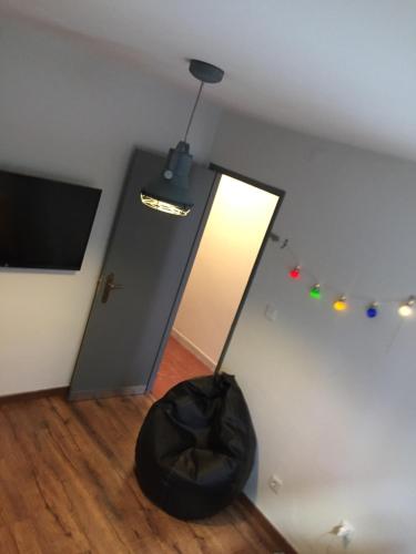 a room with a black bean bag chair and a television at Casa da Joana! in Murça