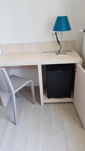 a desk with a blue lamp and a chair at Cecio 5 Terre Rooms in Corniglia