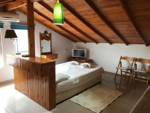 1 dormitorio con 1 cama con espejo y TV en Calypso Cozy Suites en Dalyan