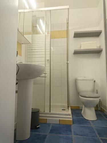 une salle de bain avec toilettes et douche en verre dans l'établissement Lesage, à Lorient