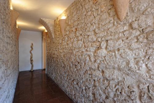 a hallway with a stone wall with a statue at Best Western Hotel du Roy d'Aragon in Bonifacio