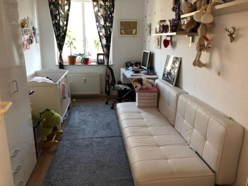 a living room with a white couch and a desk at BS Business Travelling Hannover City in Hannover