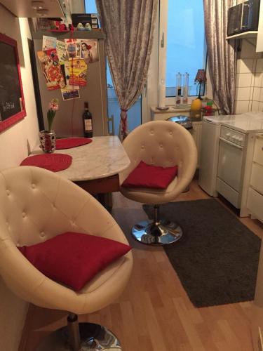 a kitchen with a table and two chairs with red pillows at BS Business Travelling Hannover City in Hannover