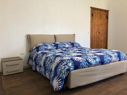 a bedroom with a bed with a blue and white comforter at Villa Giulia in Lamezia Terme