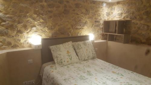 a bedroom with a bed with two pillows and two lights at Charmant Appartement Neuf Le Taoume in Éoures