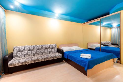 トムスクにあるСовременная 1к квартира, ост. Дальне-Ключевскаяのベッド2台とソファが備わる小さな客室です。