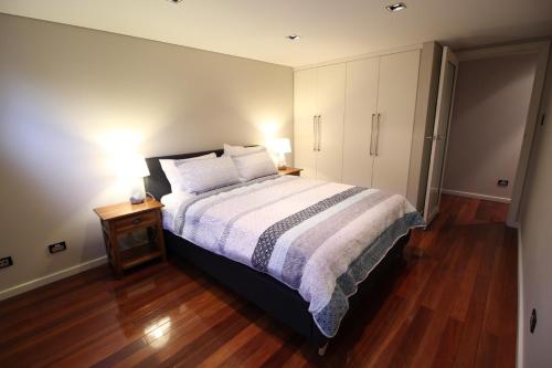 a bedroom with a large bed and a night stand with a nightstand at Sunny 3 Bedroom Apartment in Sandy Bay in Sandy Bay