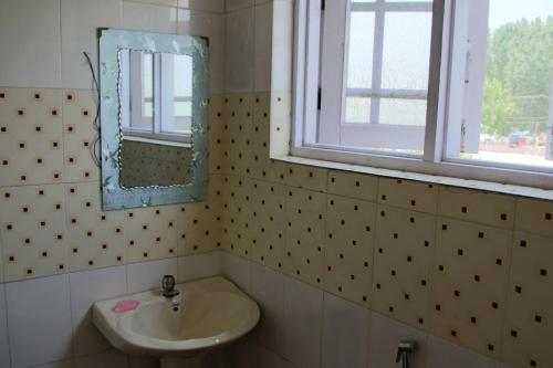 y baño con lavabo y espejo. en Hotel Chachoo Palace en Srinagar