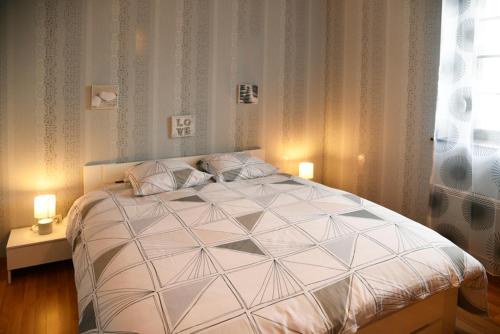 1 dormitorio con 1 cama blanca grande y 2 lámparas en Les pieds dans l'eau,la tête dans les nuages en Luxeuil-les-Bains