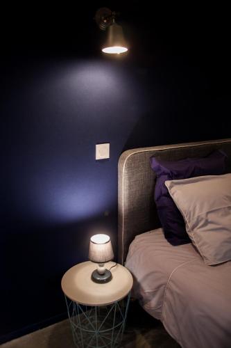 a lamp on a table next to a bed at Villa Des Ursulines in Bayeux