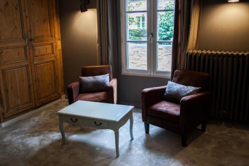 ein Wohnzimmer mit 2 Stühlen und einem Couchtisch in der Unterkunft Villa Des Ursulines in Bayeux