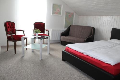 een slaapkamer met een bed en een tafel en stoelen bij Viesu nams AMRAI in Ventspils