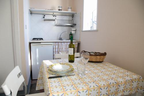 a table with a bottle of wine and glasses on it at Lo Splendore del Borgo in Tropea
