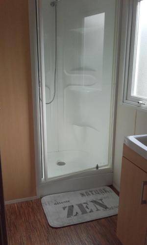 a shower in a bathroom with a mat on the floor at Mobile Home Service Hotelier in Fréjus