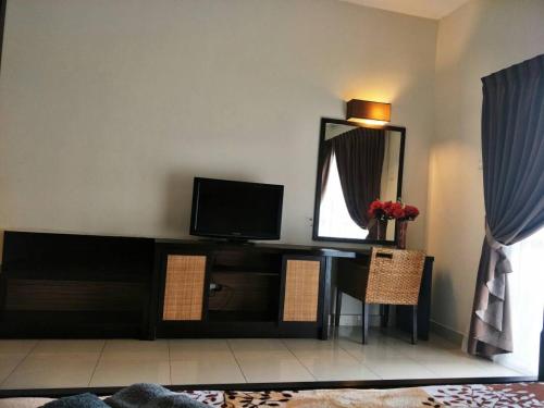 Zimmer mit einem Schreibtisch, einem TV und einem Spiegel in der Unterkunft Lala House, Gold Coast Morib Resort in Banting