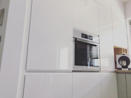 Un four micro-ondes est installé au-dessus d'un réfrigérateur. dans l'établissement Art Apartament, à Zielona Góra