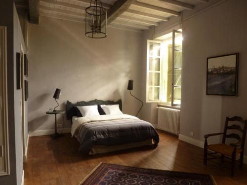 a bedroom with a bed and a chair and a window at DOMAINE D'ENTUDELLE in Lussan