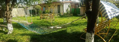 a hammock in a yard next to a house at Guest House Villa in Kvareli