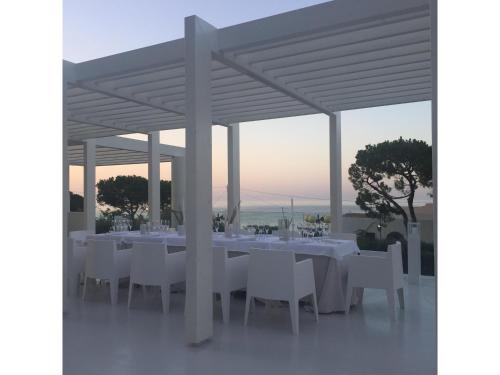 a table with white tables and chairs under a pavilion at La Chiave dei Trabocchi in San Vito Chietino