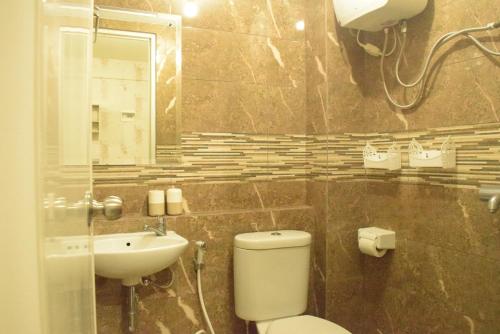 a bathroom with a toilet and a sink and a mirror at Pakubuwono Terrace Apartment in Jakarta