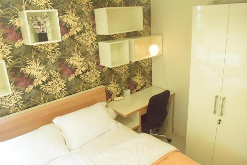a bedroom with a bed and a desk and a wall at Pakubuwono Terrace Apartment in Jakarta