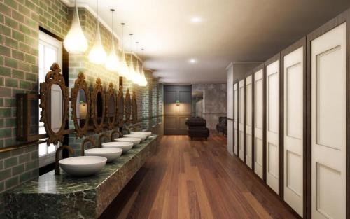 La salle de bains est pourvue d'une rangée de lavabos et de miroirs. dans l'établissement The George Hotel Wetherspoon, à Brecon